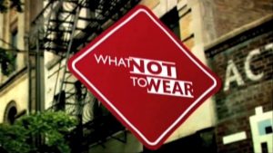 Red diamond sign with "What Not to Wear" text, set against a blurred city building and foliage background.