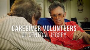 Two elderly people sitting together inside, with text: "Caregiver Volunteers of Central Jersey.